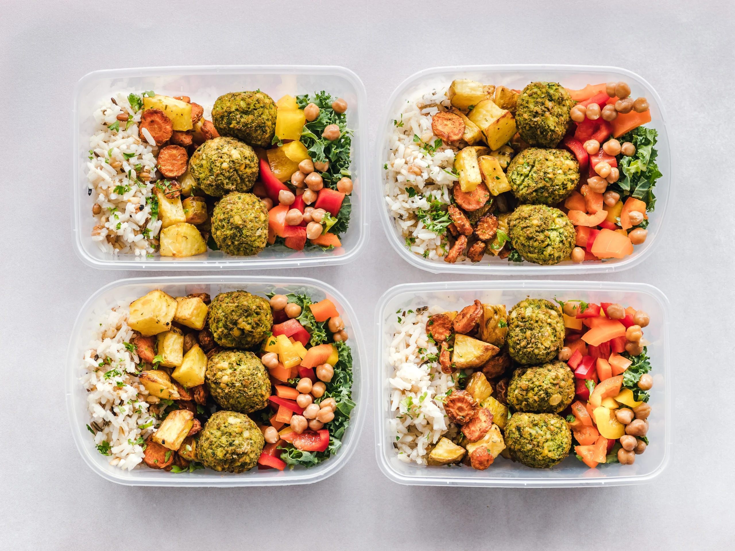 Colorful meal prep containers with falafel, chickpeas, rice, and vegetables for a healthy lifestyle.
Colorful meal prep containers with falafel, chickpeas, rice, and vegetables for a healthy lifestyle.